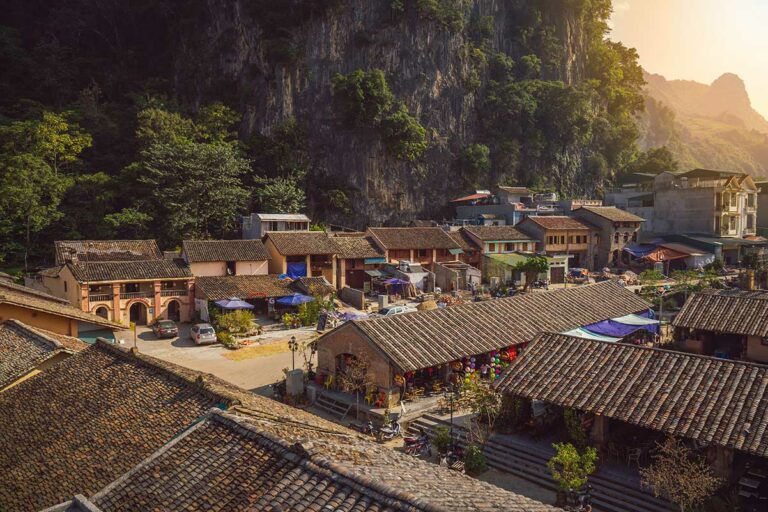 Panoramisch uitzicht op Dong Van Old Quarter met oude huizen en karstkliffen op de achtergrond.