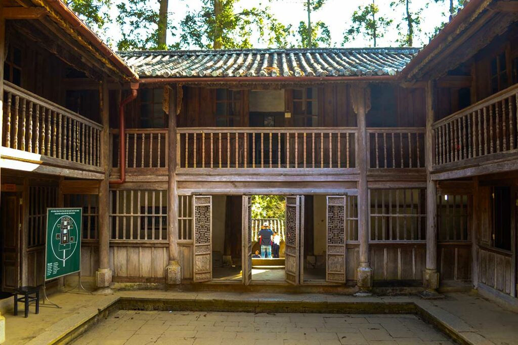 Binnenplaats van het Hmong King Palace met houten balkons en traditionele architectuur.